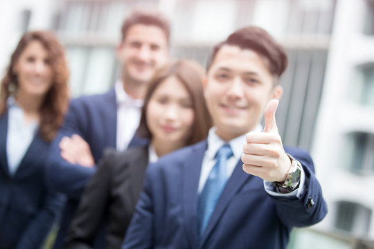 businessman smiles show thumb up