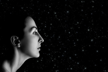 serious female profile on stars sky background with copyspace