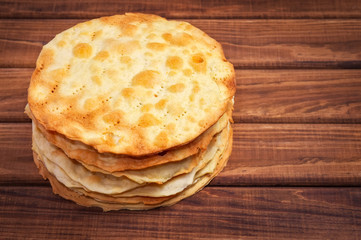 Baked korzh layers for a cake Napoleon on wooden background.