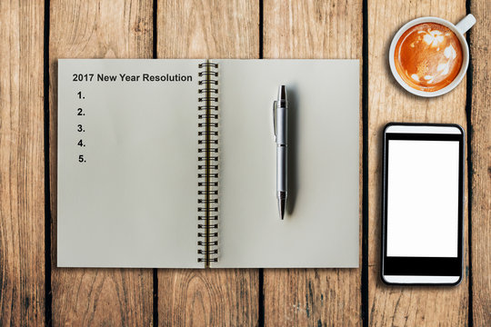 New Year Resolution 2017 as memo on notebook and coffee cup with