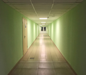 Modern interior in office building. Long empty hall with distant doors and office entrance.