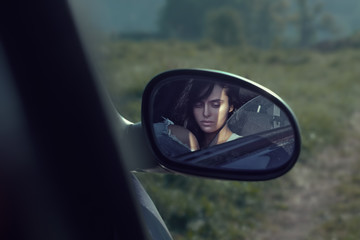 Fototapeta na wymiar Closeup sensual portrait of a beauty brunette girl in the rear-view mirror.