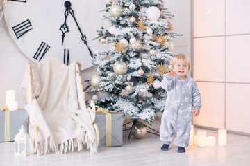 Beautiful little baby boy in pajamas with stars celebrates Christmas