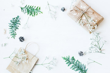 Christmas composition. Christmas gift, pine cones, thuja branches and gypsophila flowers. Top view, flat lay