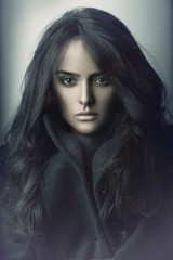 Closeup fashion portrait of a sensual brunette girl with curly hair.