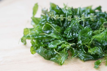 Holy basil fried on a wooden cutting board