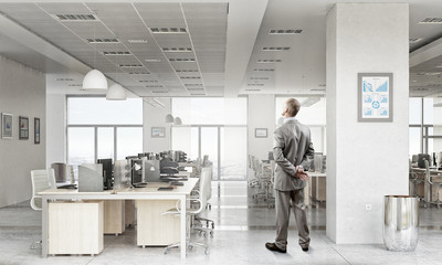 Pensive businessman in office . Mixed media