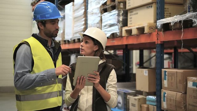 Store manager with warehouseman checking stock levels