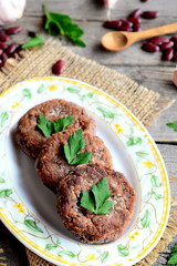 Homemade veggie burgers with red beans, garlic and spices. Red bean burgers recipe. Ingredients for cooking cutlets. Old wooden background. Vintage style. Closeup