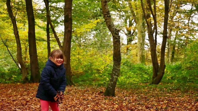 enfant jouant avec les feuilles en automne