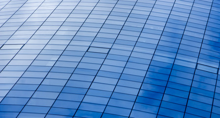 Fototapeta premium wall glass skyscraper with reflection of the sky at night.