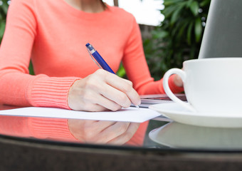 Woman working on computer and writing down her thoughts.     © kieferpix