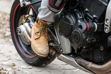 Biker on motorcycle, close-up view on legs.