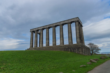 Fototapeta na wymiar The unfinished National Monument, built to commemorate the soldiers of the Napoleonic Wars and Nelson Monument on Calton Hill, Edinburgh, Scotland, UK.