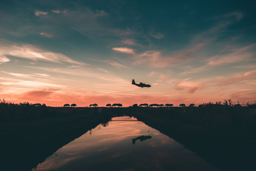Passenger Turbofan Airplane is Approaching at the Airport with the Gears down on the top of a Little torrent. Mirror on the Torrent.