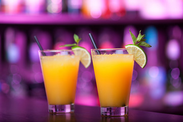 Two Harvey Wallbanger cocktail shot on a bar counter in a night