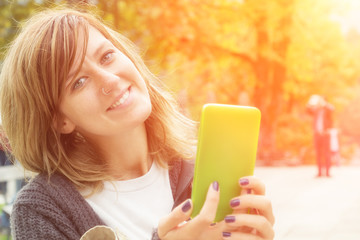 Girl using cellphone outdoors.