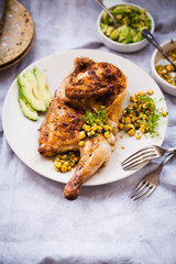 Roasted chicken with avocado, corn sauce on a platter. 