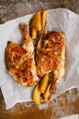Roasted chicken with apple lemon slices on a platter. 