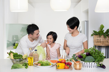 Obraz na płótnie Canvas Happy Asian family preparing food in the kitchen.