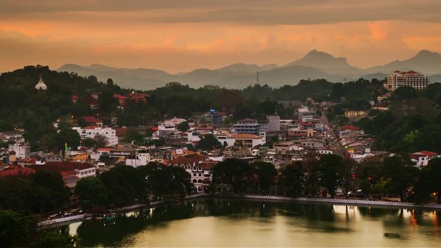 Lake in Kandy. Time-lapse of a sunset over the former capital of Sri Lanka. Panoramic view at night with car light trails