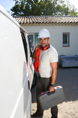 young electrician artisan taking tools out of his professional truck van
