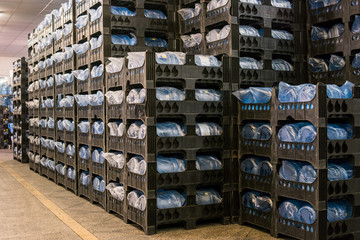 Many crates with bottles. Interior of storehouse. High quality mineral water. Each jug holds five...