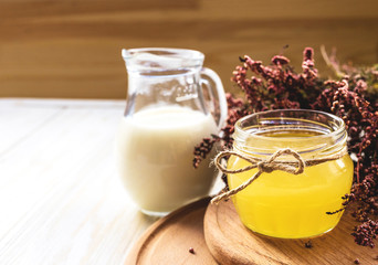 Milk, heather flowers and honey. Wooden table.