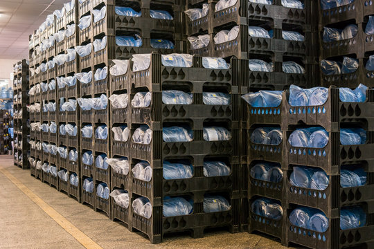 Many crates with bottles. Interior of storehouse. High quality mineral water. Each jug holds five gallons.