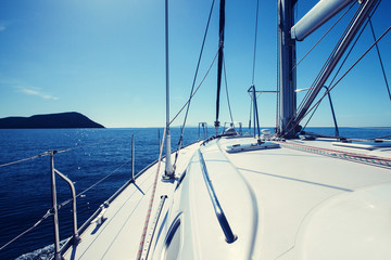 Fototapeta premium The white sails of yachts on the background sea and sky in the clouds