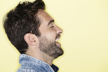 Obraz premium Laughing man against yellow background, profile