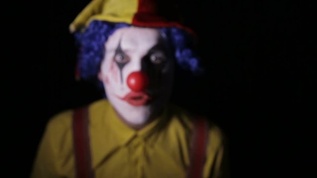 Scary clown screaming into camera faces. Close-up. HD.