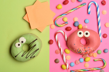 Funny glazed donuts on colorful background