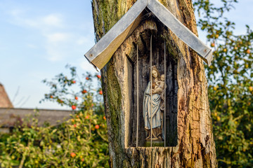 Holy Mary statuette in a niche carved out in an old tree