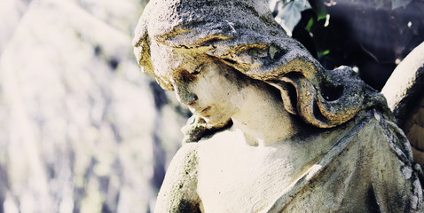 Vintage image of a sad angel on a cemetery against the backgroun