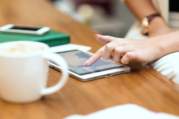 Young beautiful girl in white suit sitting in cafe