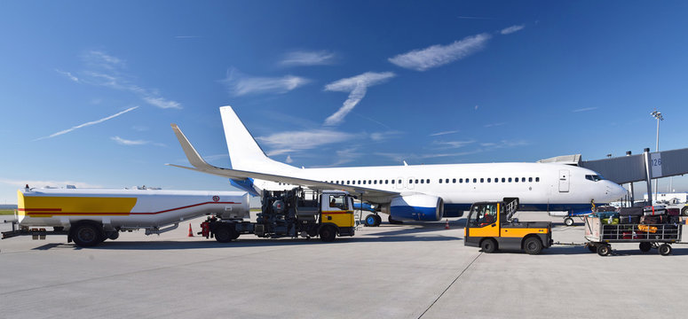 Refueling an airplane at the airport with a tanker truck // Betanken eines Flugzeuges am Flughafen mit einem Tankwagen 