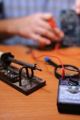 Eletrician checking circuit board by multimeter