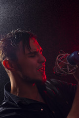 Portrait of young expressive rock singer with mic