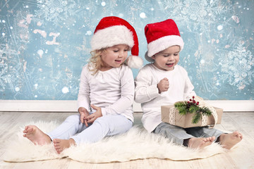 zwei kleine Kinder packen Geschenke aus, Weihnachten