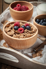 Bowl of cereals with blueberries and raspberrie.