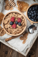 Bowl of cereals with blueberries and raspberrie.