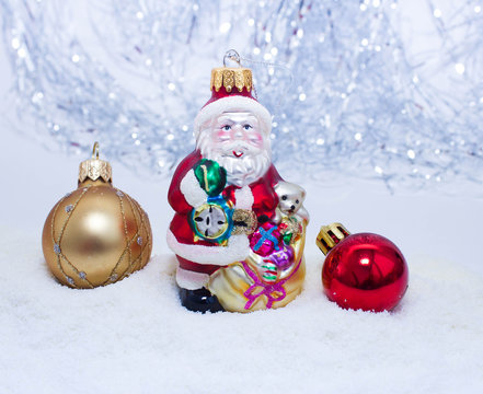 Christmas or New Year background: colored glass balls and toy, decoration on a white background with snow and sparkles