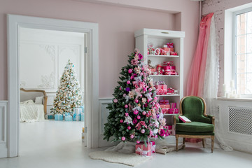Beautiful holdiay decorated rooms with Christmas trees, shelf and pink blue gifts on it, green chair home interior