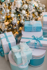 Christmas gift boxes with blue bow and bokeh lights on wooden surface