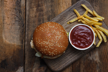 Fresh home-made hamburger served on wood. Wooden background. Tasty hamburger with chicken. View from above.