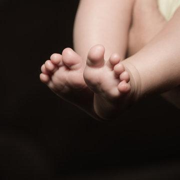Newborn baby feet isolated on black