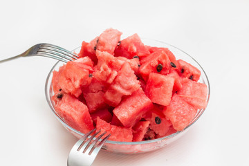 watermelon pieces in bowl with fork on white background
