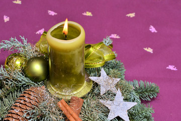 Weihnachtsgesteck mit brennender Kerze