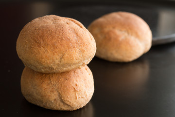 Three homemade fresh bread buns on black background 